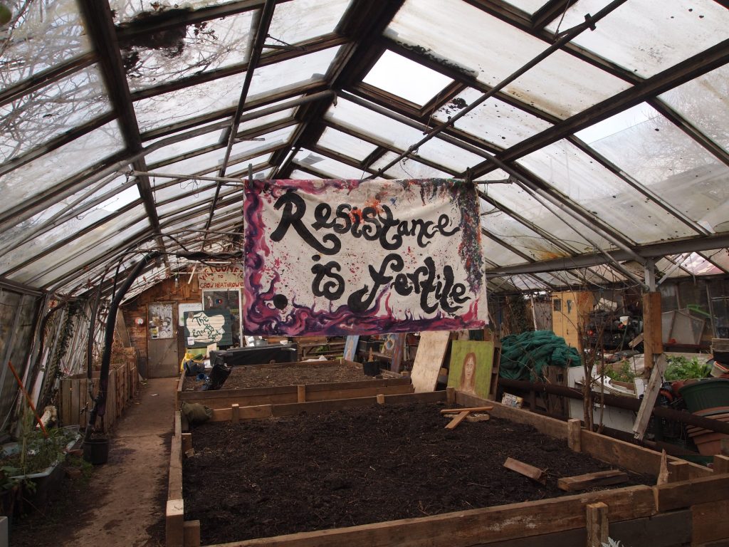 A handmade banner hung in one of Grow Heathrow's polytunnels reads "Resistance is Fertile"